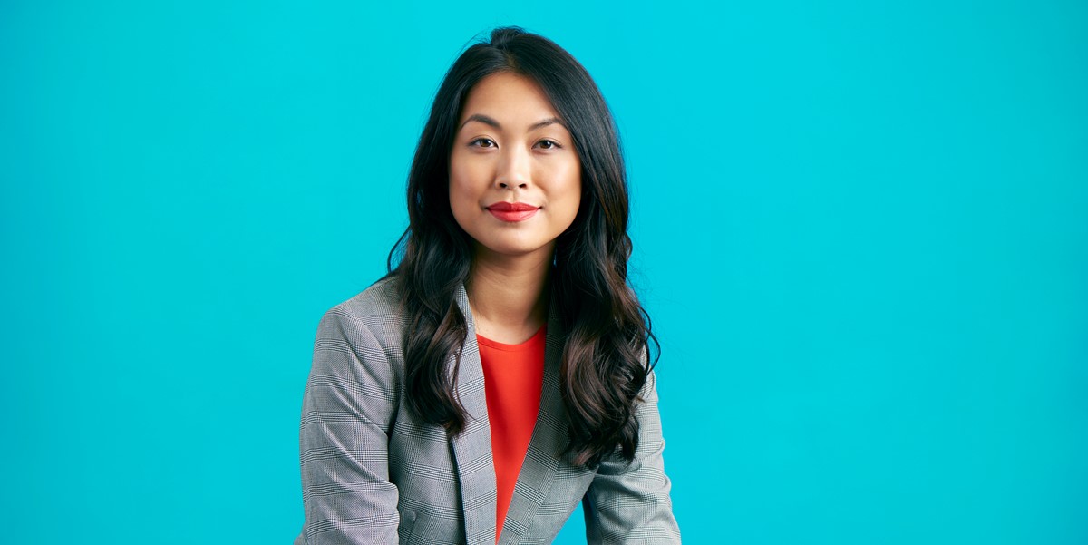 woman smiling, in front of blue background