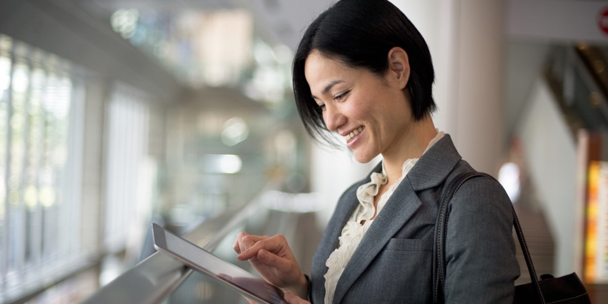 woman in office looking at phone in hand