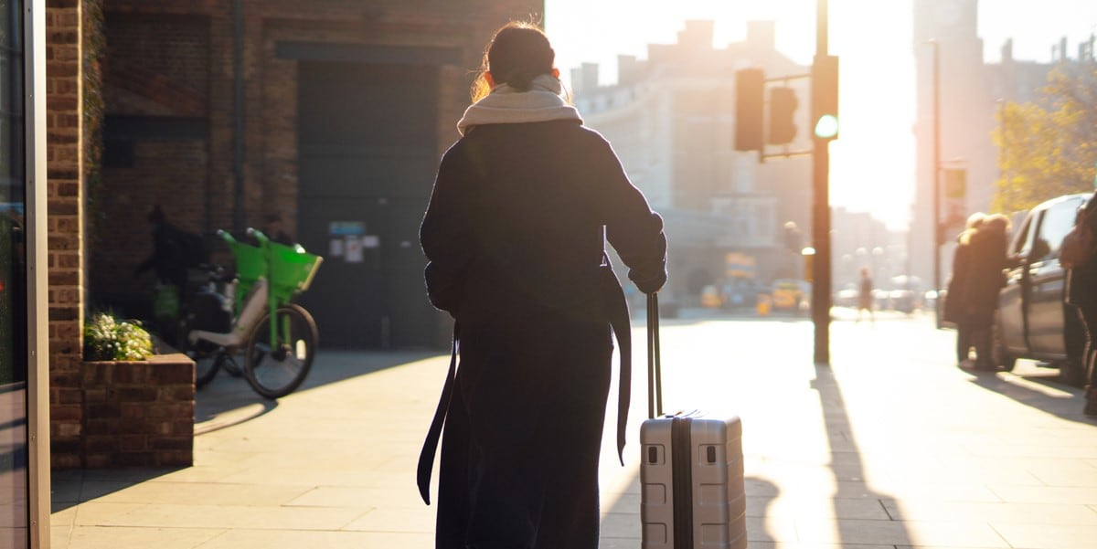 traveler walking through city with luggage