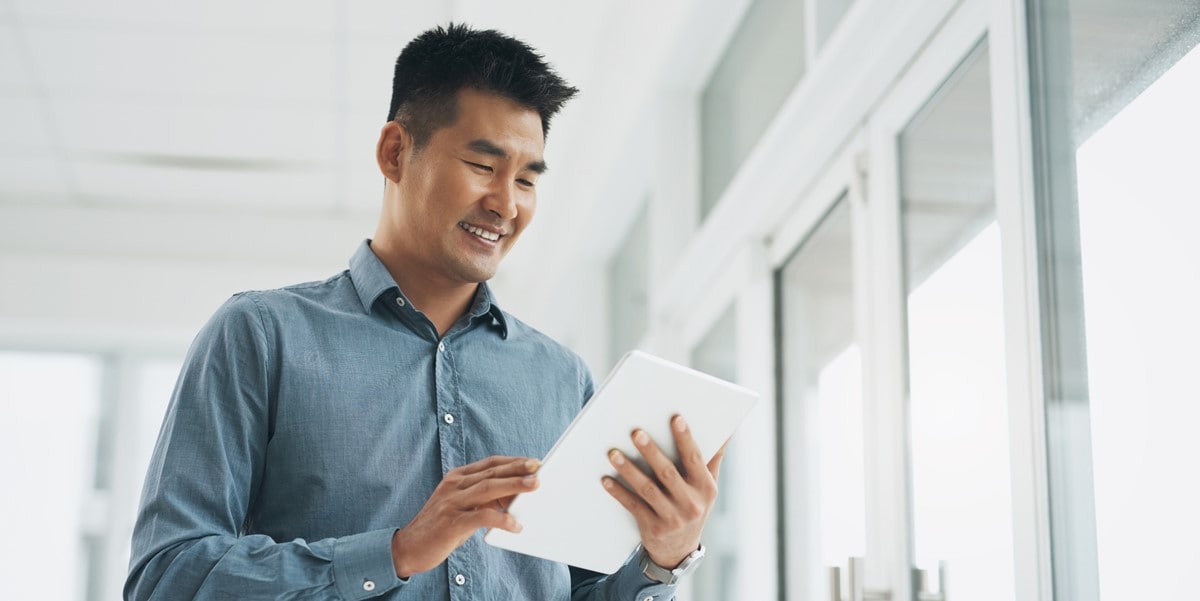 man in office, holding tablet