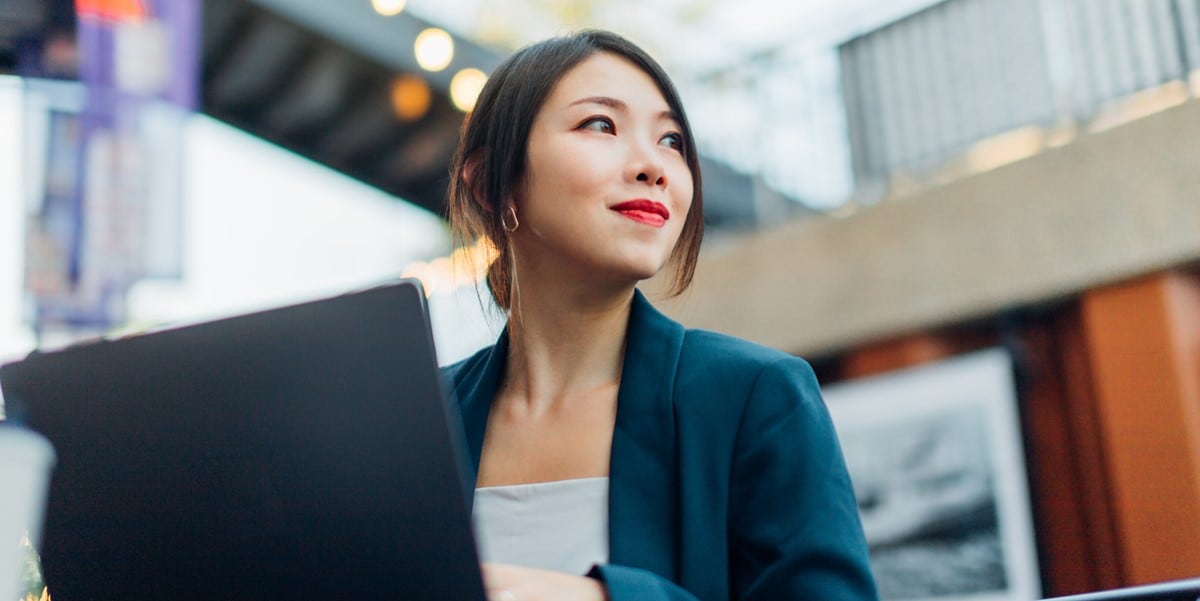 woman working in office, laptop in front of her